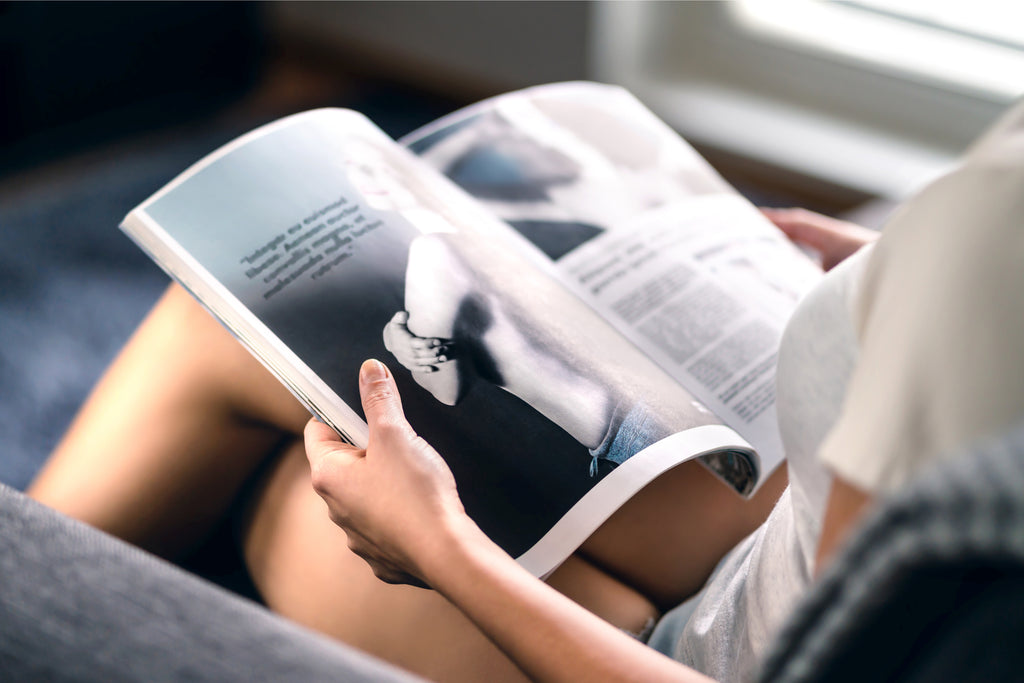 Woman reading magazine on couch